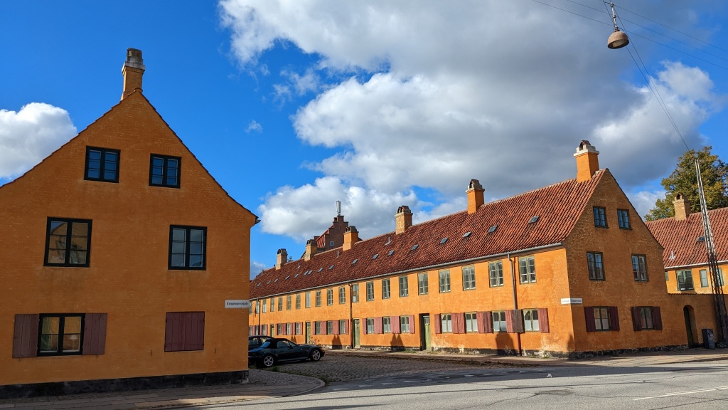 bright yellow row houses against a blue sky with clouds in Copenhagen
